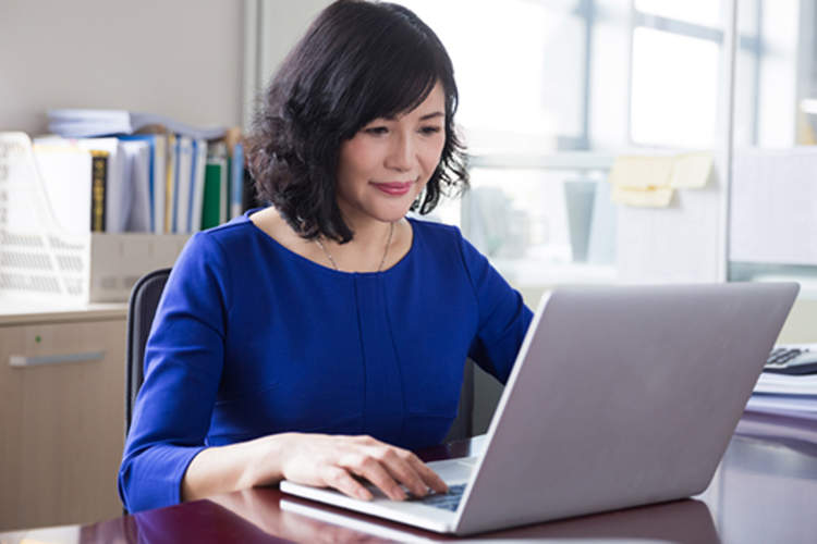 成年女性在笔记本电脑上。