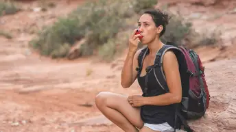 一个徒步旅行时用吸入器的女人。
