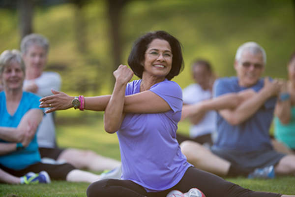 中年妇女在户外运动类拉伸。