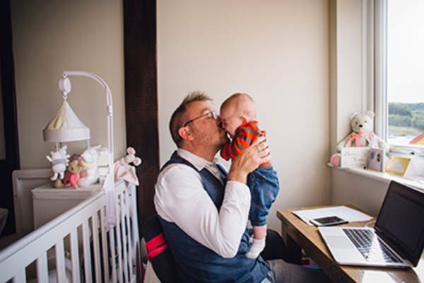 年长的父亲抱着一个啼哭的婴儿。