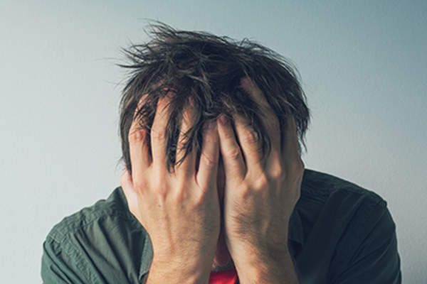 强调人与他的手在他的脸上。