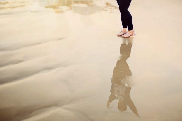 女人站在水，反射双臂抬起