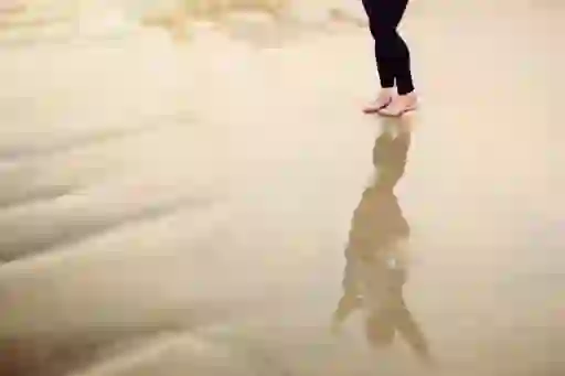 女人站在水中,手臂在反射