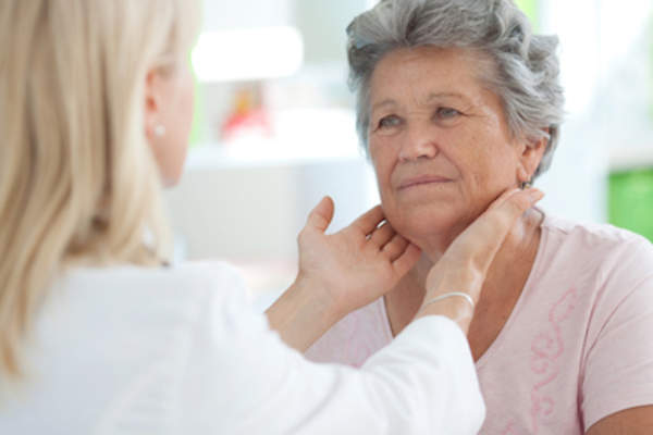 医生检查妇女的甲状腺。