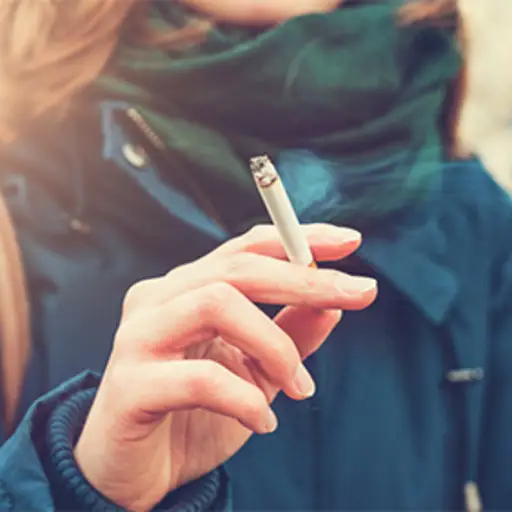 女人穿着冬天的夹克和围巾抽着烟。