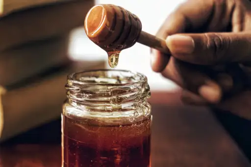 手拿蜂蜜从罐子外面