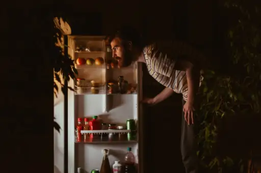 男人在晚上看冰箱