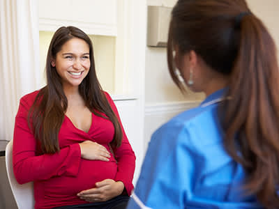 快乐年轻的孕妇在医生预约。