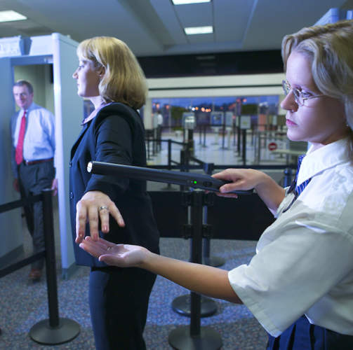 一名机场旅客被TSA用魔杖检查。