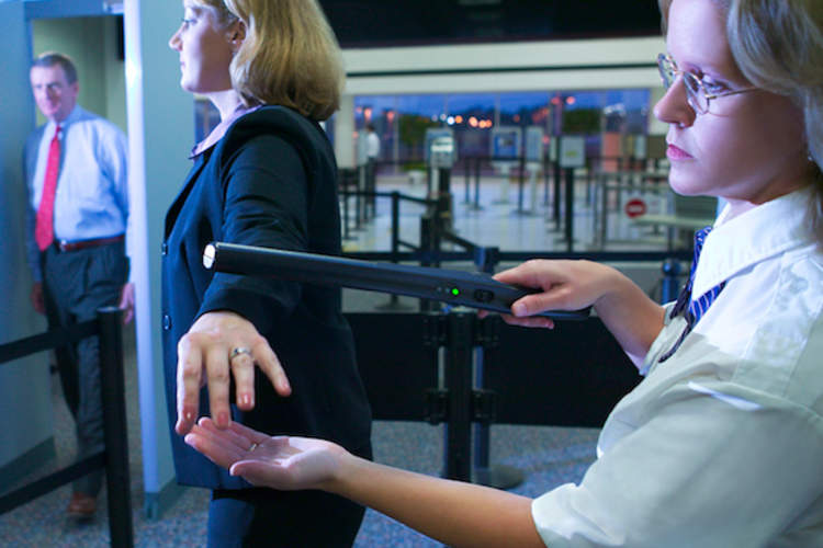 一名机场旅客被TSA用魔杖检查。