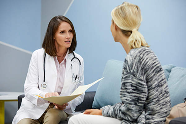 妇女询问她的医生关于血清类风湿关节炎。