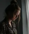悲伤的女人站在窗边