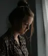 sad woman standing near window