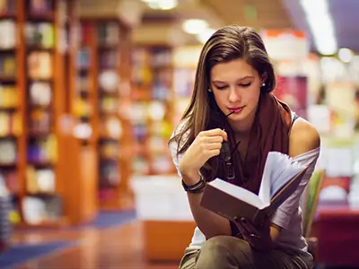 读书在图书馆里的女孩。