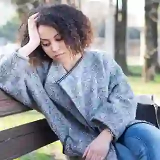 Sad woman seated alone on a bench