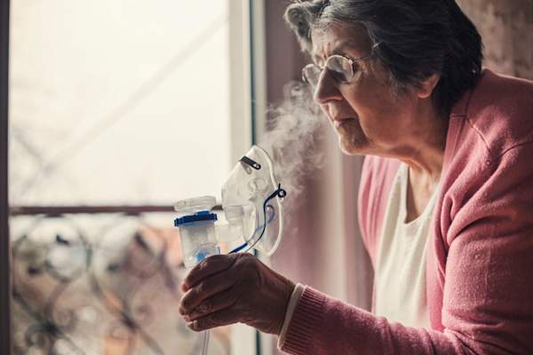 使用喷雾器,以帮助肺纤维化的高级女子