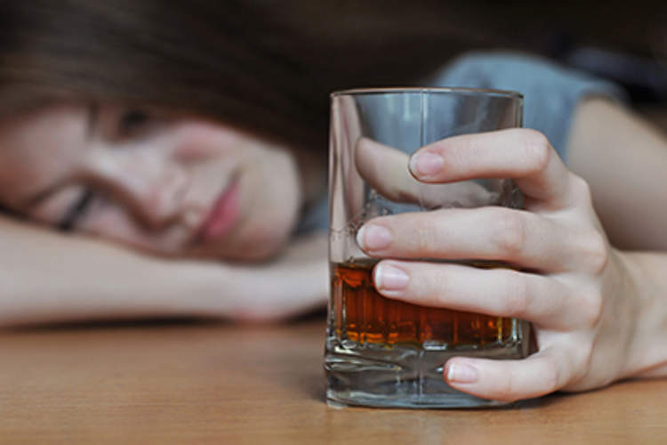 年轻女孩拿着一杯烈酒。