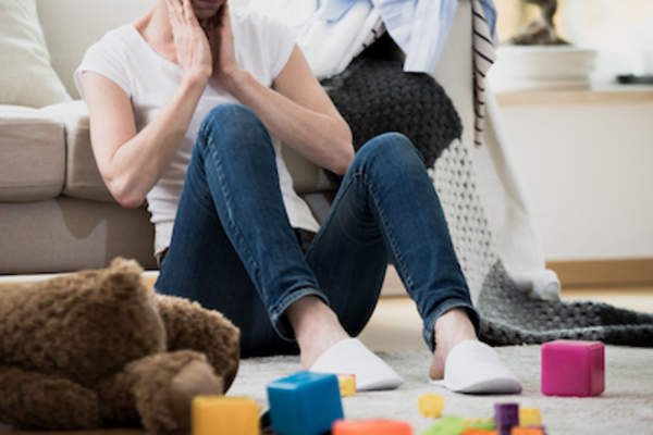 疲惫的女人坐在地板上。