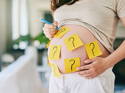 一名孕妇在她的胃里贴满了问号。