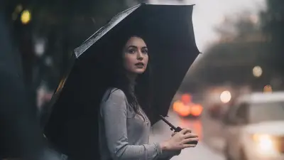 暴风雨中站在伞下的妇女