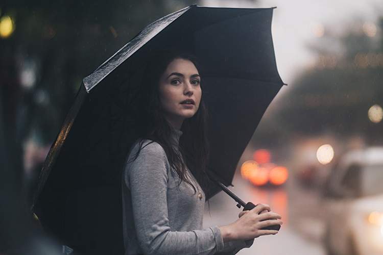 暴风雨中站在伞下的女人
