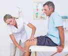 Physical Therapist examines mans knee