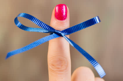 蓝色丝带系在妇女的手指上，以提高对结肠癌的认识。