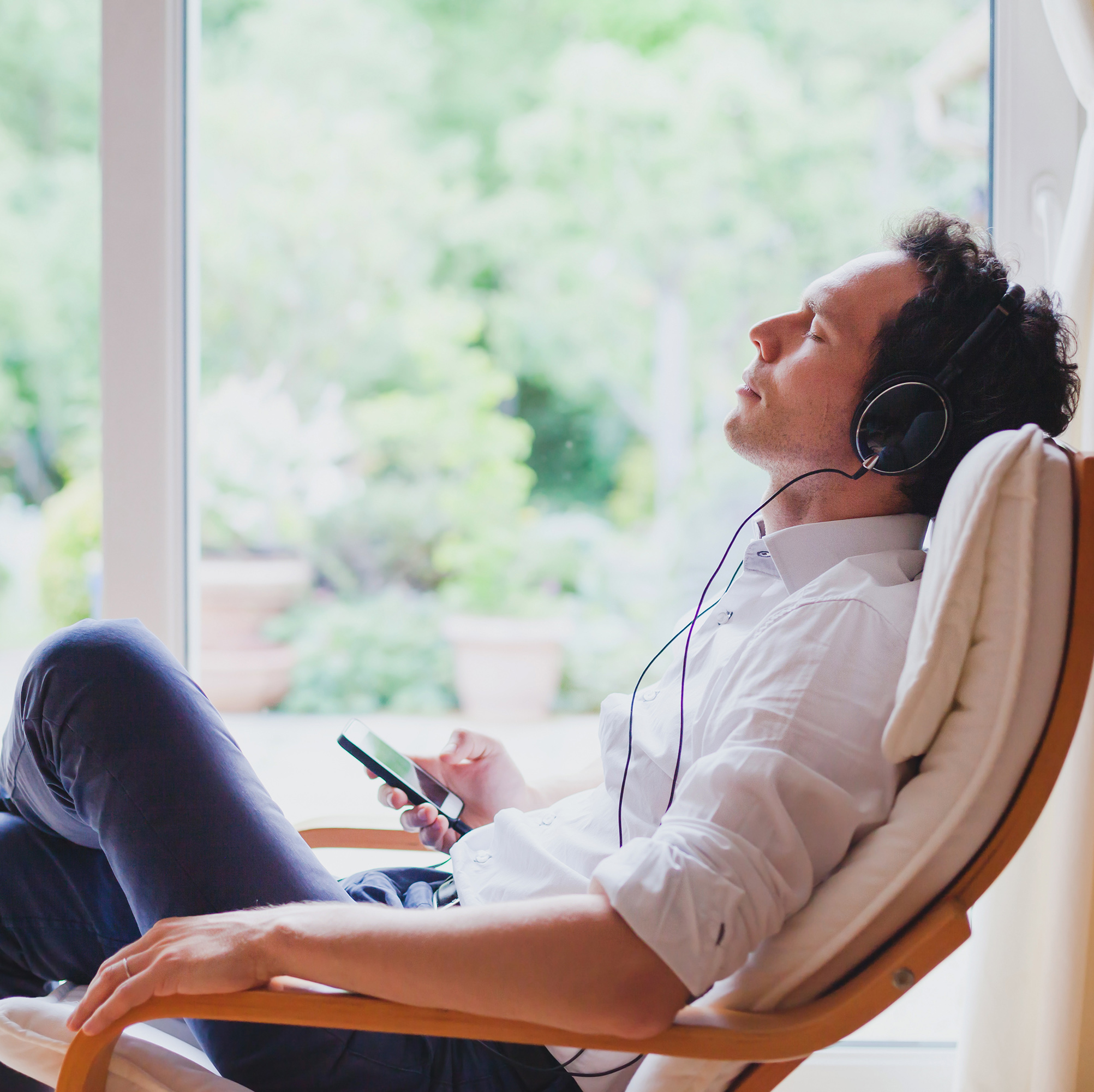 放松人的耳机坐在躺椅