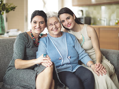 三个微笑的女人坐在沙发上。