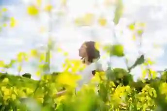 一个女人站在黄色花朵的田野里