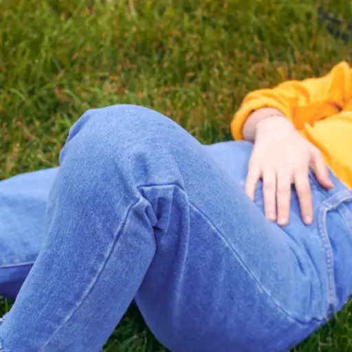 穿着牛仔裤躺在草地上的人