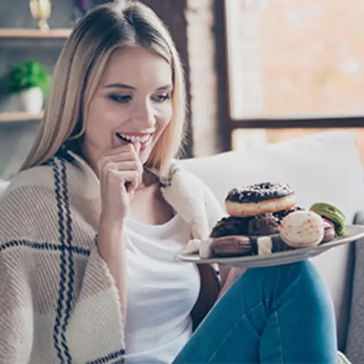 Woman holding a plate of desserts.