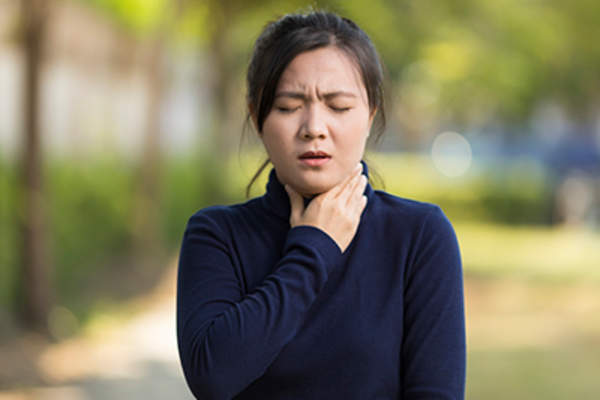 年轻女子的喉咙疼痛行走之外。