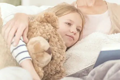 一个小女孩抱着一只泰迪熊。