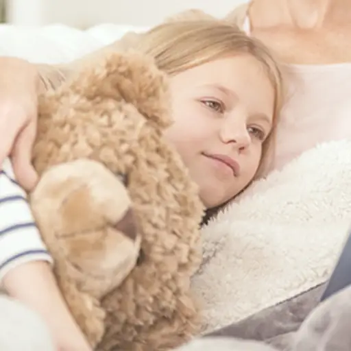 一个小女孩抱着一只泰迪熊。