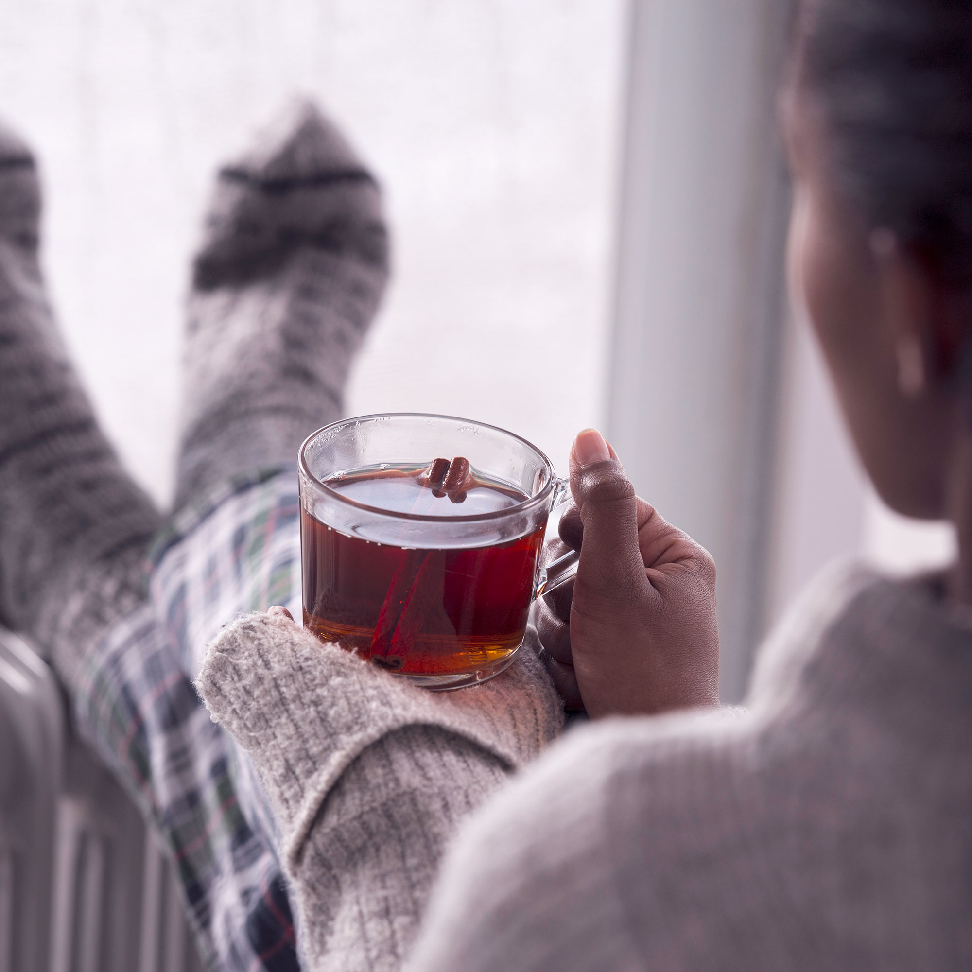 一个女人端着一杯茶坐着