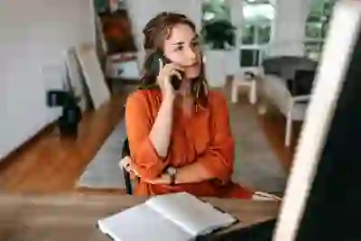 一个女人在电话上交谈时看着她的计算机