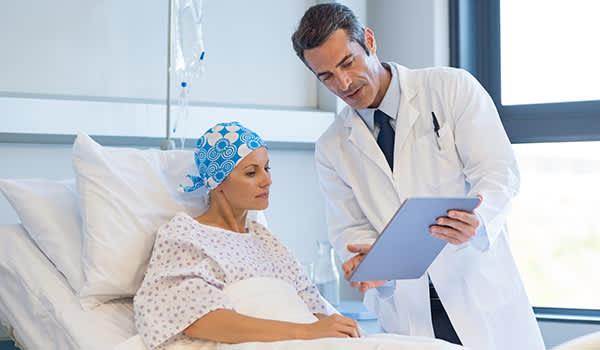 医生向一位乳腺癌患者展示药片。