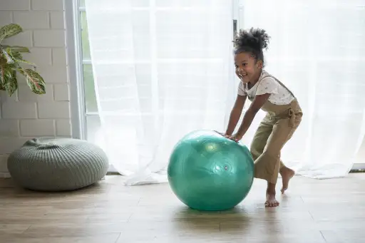 Little girl playing with exercise ball