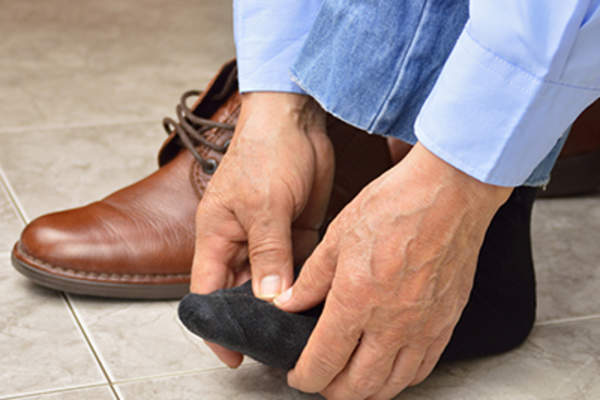 那个人搓揉他肿胀的脚。