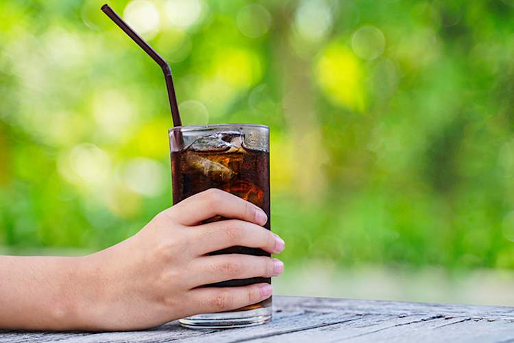 女子抱着苏打玻璃吸管。