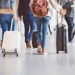 People walking through airport with luggage. 