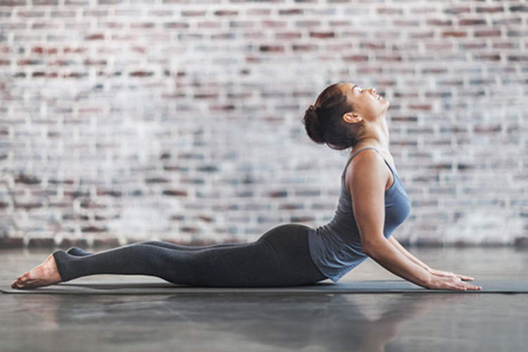 女人做在地板上瑜伽。