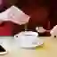 A woman pours sweetener into a cup of coffee