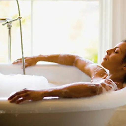 放松在泡影浴的妇女。