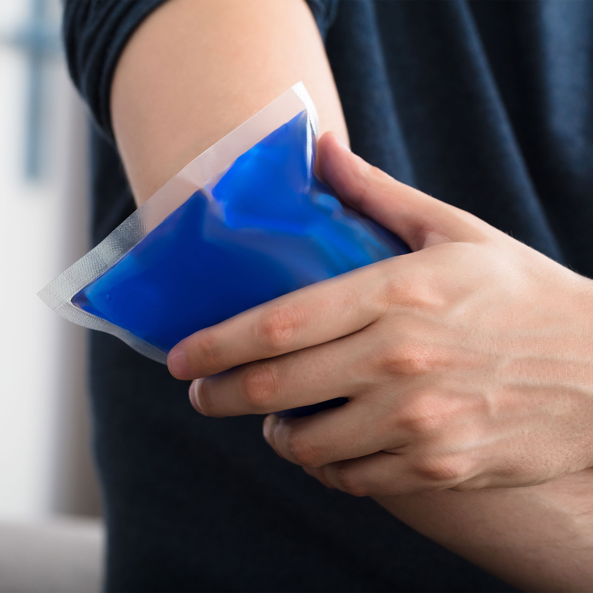 有人在肘上涂上冰凝胶包的人的特写镜头