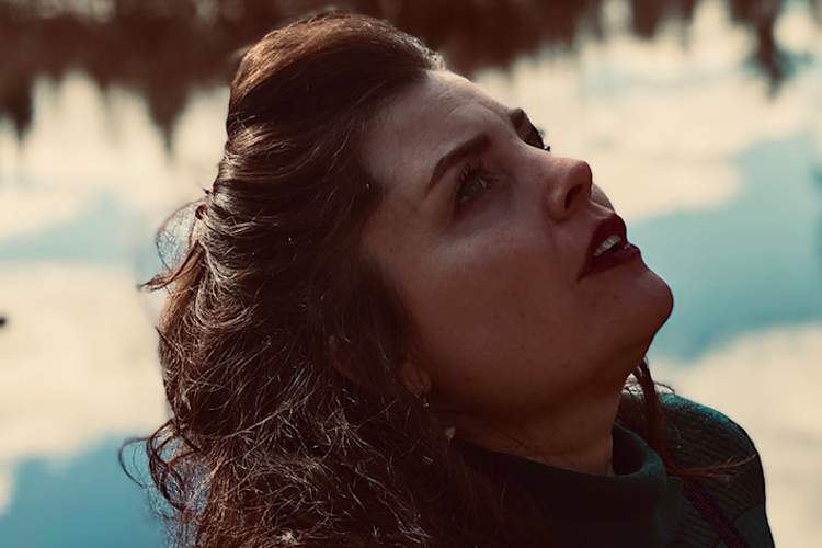 一位老女人望着前面的湖。