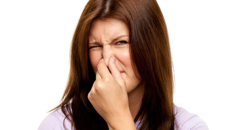 一个女人因为一股难闻的气味捏住了她的鼻子。