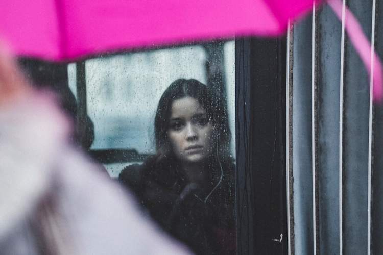 伤心的女人在雨中望着窗外