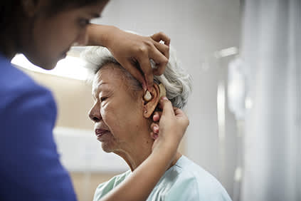 为老年病人安装助听器。